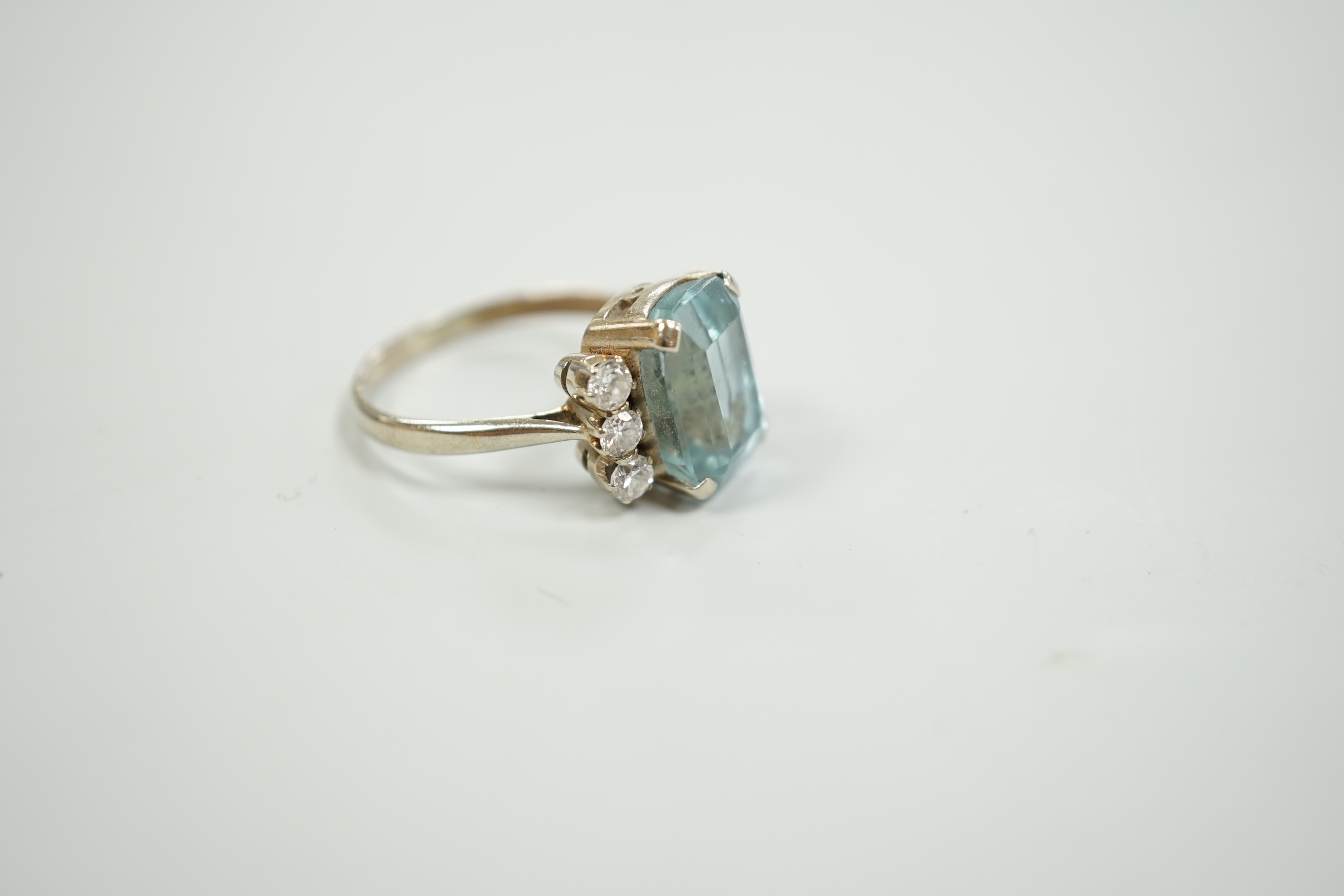 A white metal and single stone emerald cut aquamarine and six stone diamond set dress ring, size P/Q, gross weight 4.2 grams.
